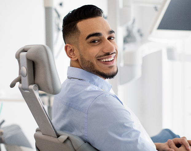 Male dental patient smiling in dental chair