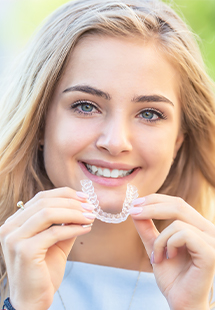 woman holding a clear aligner