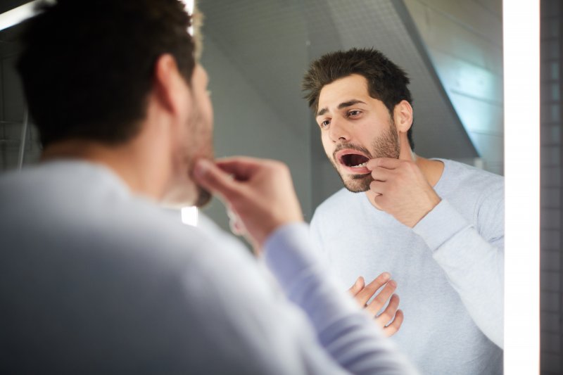 Patient checking for gingivitis in the mirror